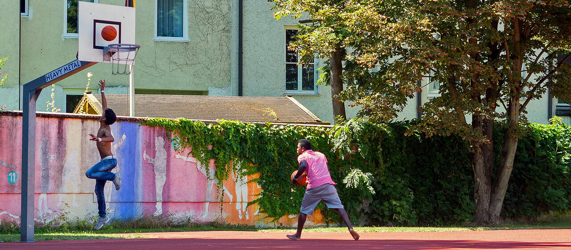 Zwei junge Flüchtlinge trainieren Basketball.