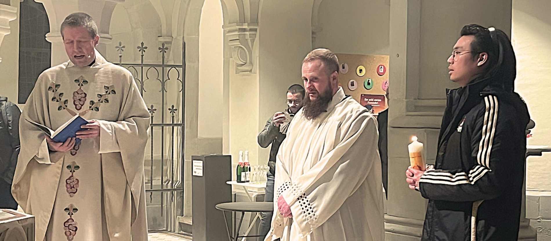 Als Zeichen für die Taufe hat Kade Quarles ein weißes Gewand erhalten. Sein Taufpate Isaac hält die Taufkerze.