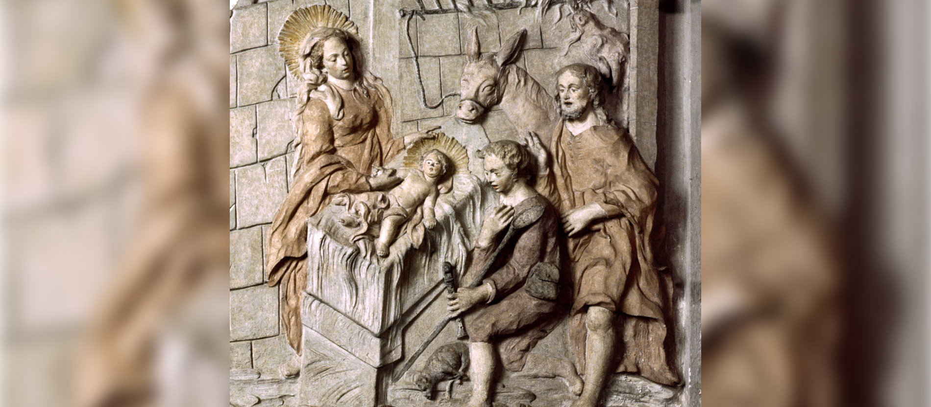 Auf dem Krippenrelief im Trierer Dom beugen sich Maria und Josef über das Jesuskind.