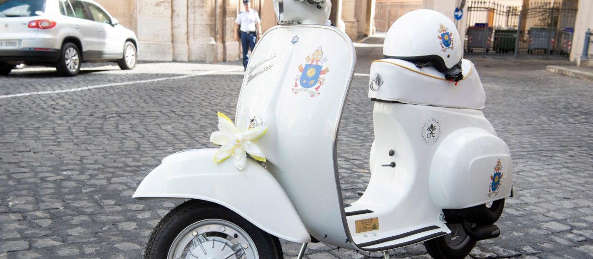 Eine weiße Vespa mit Papstwappen