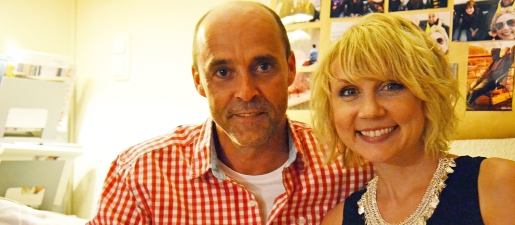 Sportlicher schlanker Mann mit Glatze sitzte neben einer strahlenden blonden Frau.